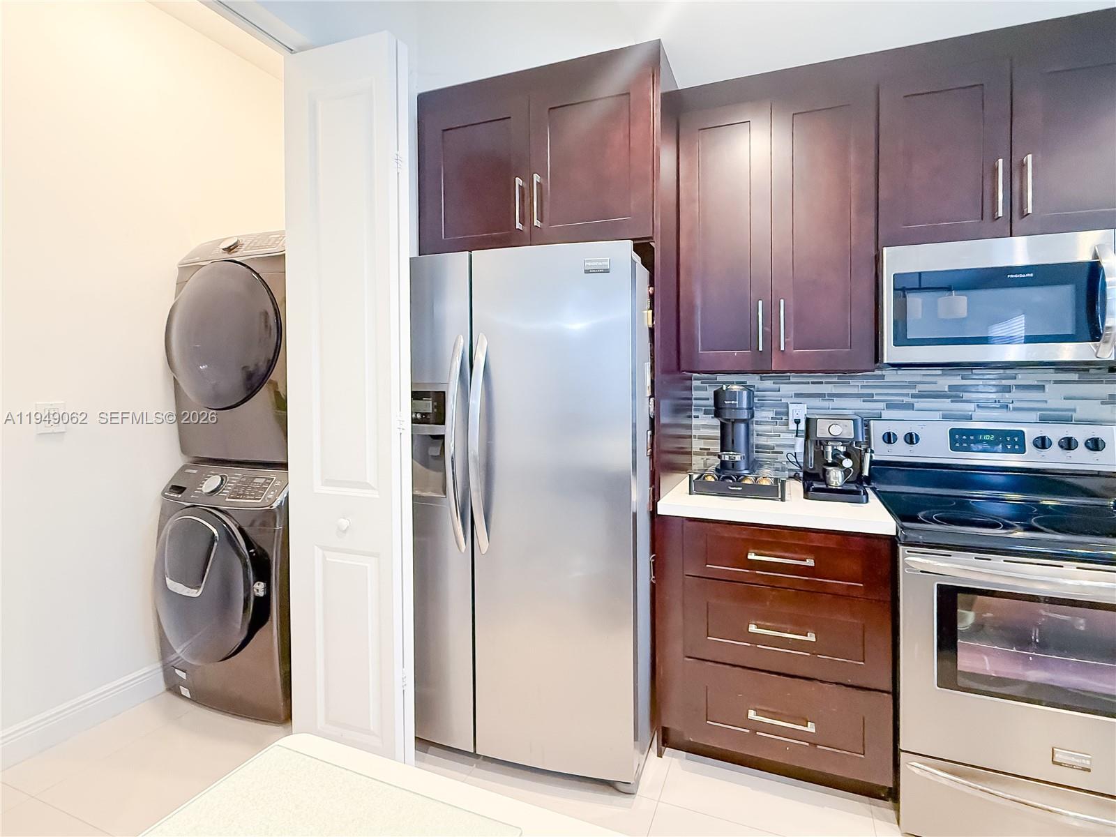 17931 Southwest 152nd Avenue Miami, FL 33187 - Photo 7 of 29 a kitchen with a refrigerator and a stove top oven