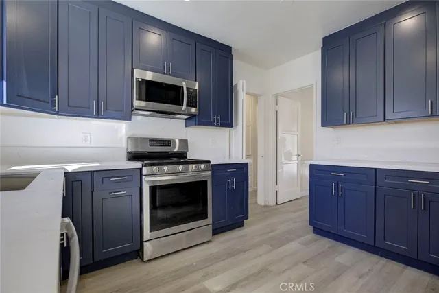 a kitchen with stainless steel appliances granite countertop a stove a microwave and a refrigerator