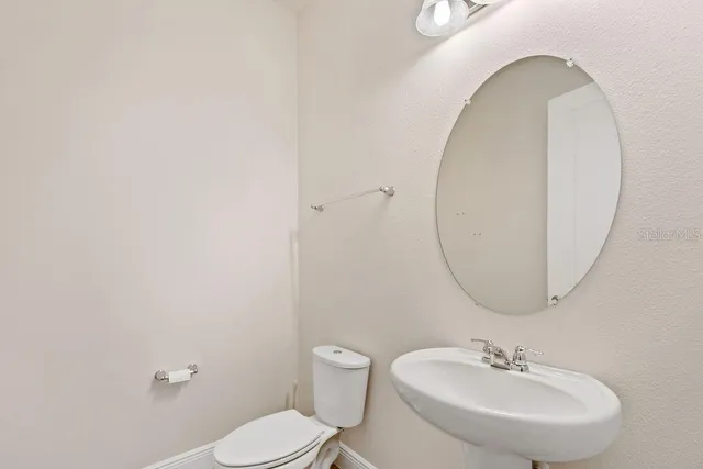 a bathroom with a sink a mirror and a toilet