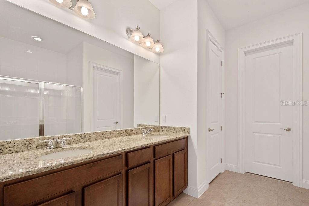 17538 Black Rail Street Windermere, FL 34786 - Photo 15 of 32 a bathroom with a granite countertop sink and a mirror
