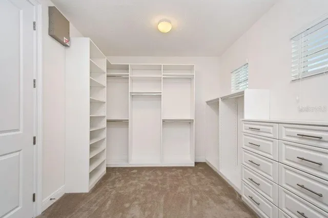 a view of walk in closet with empty racks