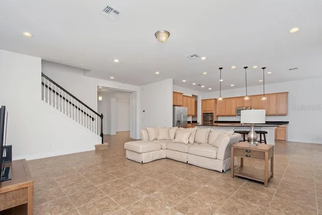 a living room with furniture and a dining table with wooden floor