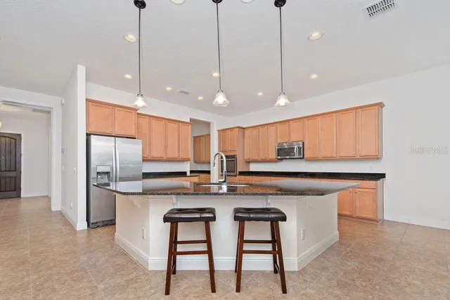 a kitchen with kitchen island a stove a sink and a refrigerator