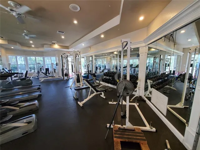 a view of a room with gym equipment and large windows