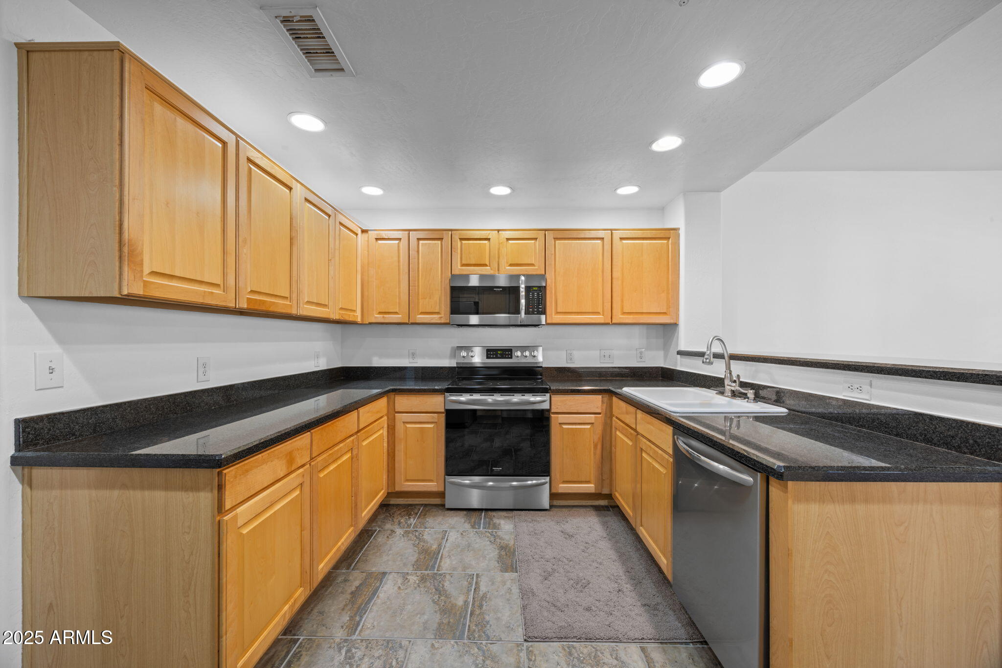 19700 North 76th Street, Unit 1040 Scottsdale, AZ 85255 - Photo 7 of 30 a kitchen with stainless steel appliances granite countertop a sink and cabinets