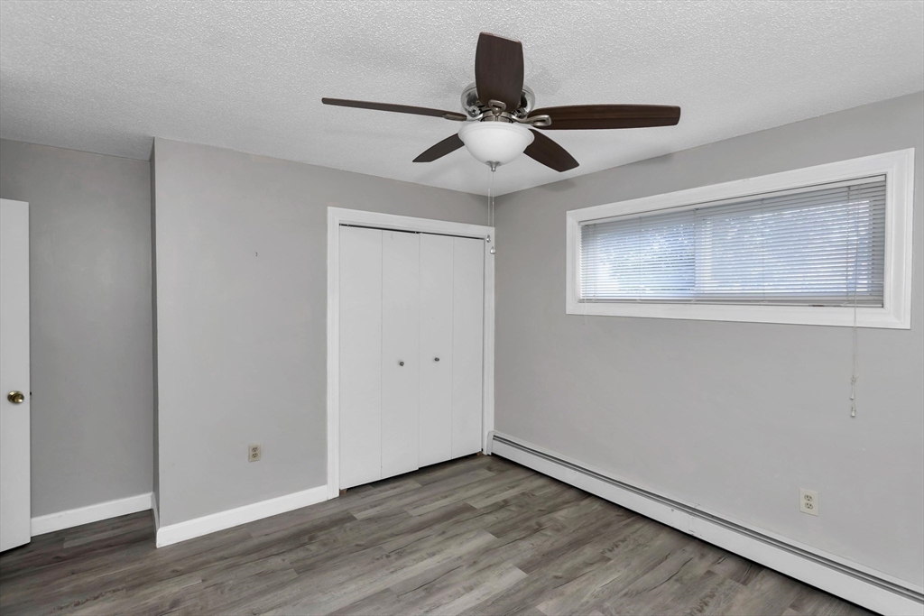 97 Collins Street, Unit 97 Chicopee, MA 01022 - Photo 18 of 21 a view of an empty room with wooden floor and a ceiling fan