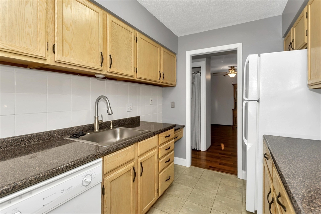97 Collins Street, Unit 97 Chicopee, MA 01022 - Photo 7 of 21 a kitchen with granite countertop a sink a stove and cabinets