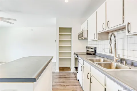 a kitchen with kitchen island a sink stainless steel appliances and cabinets