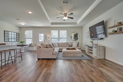 a living room with furniture and a wooden floor