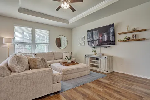 a bedroom with a bed a mirror and a flat tv screen on dresser