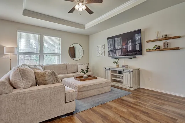 a bedroom with a bed a mirror and a flat tv screen on dresser