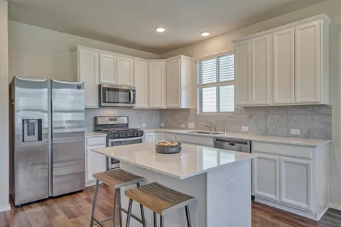 a kitchen with a sink stove and refrigerator