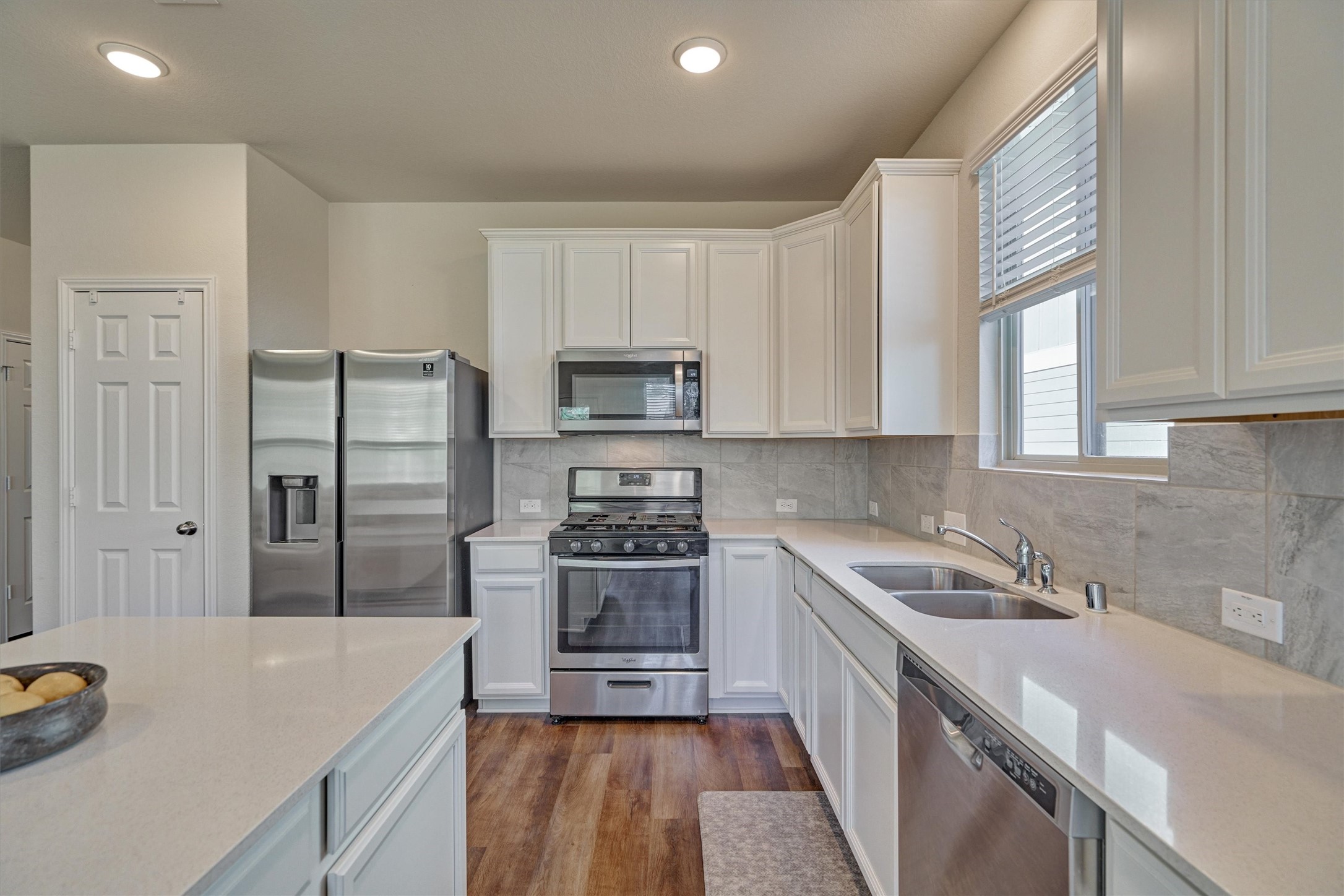 4417 Longleaf Timbers Court Conroe, TX 77304 - Photo 19 of 30 a kitchen with a sink stove and refrigerator