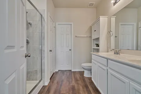 a en suite bathroom with a double vanity sink a mirror and a shower