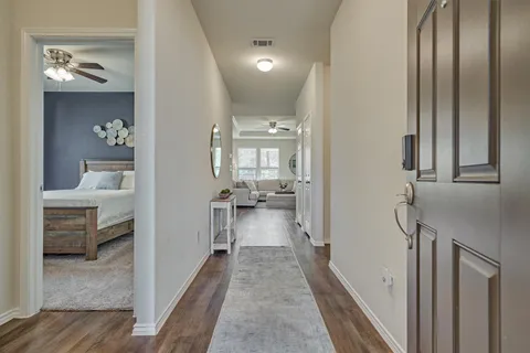 a view of a hallway with wooden floor and door