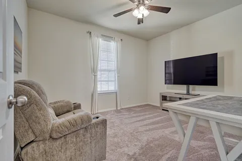 a living room with furniture and a ceiling fan