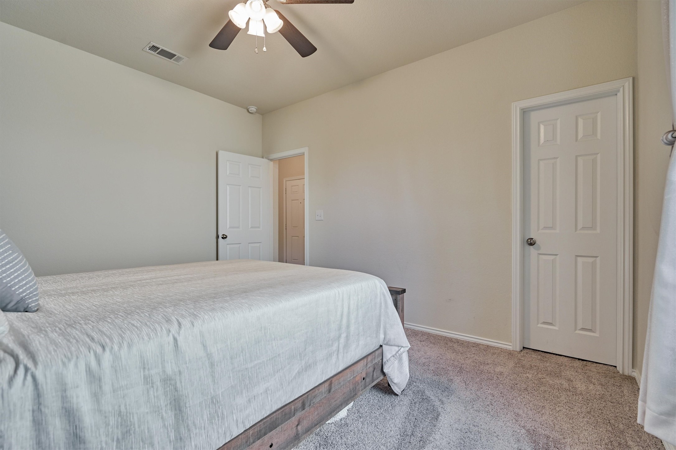 4417 Longleaf Timbers Court Conroe, TX 77304 - Photo 10 of 30 a bedroom with a bed and a chandelier