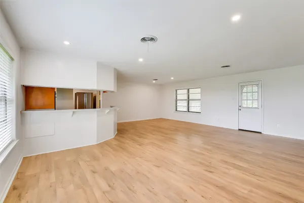 a view of empty room with wooden floor and windows