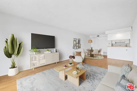 a living room with furniture a flat screen tv and a dining table with wooden floor