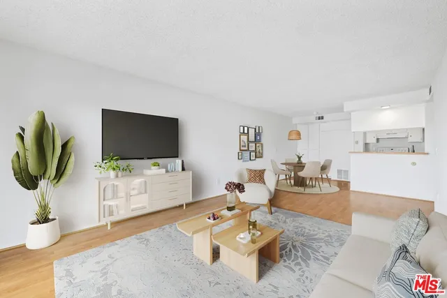 a living room with furniture a flat screen tv and a dining table with wooden floor