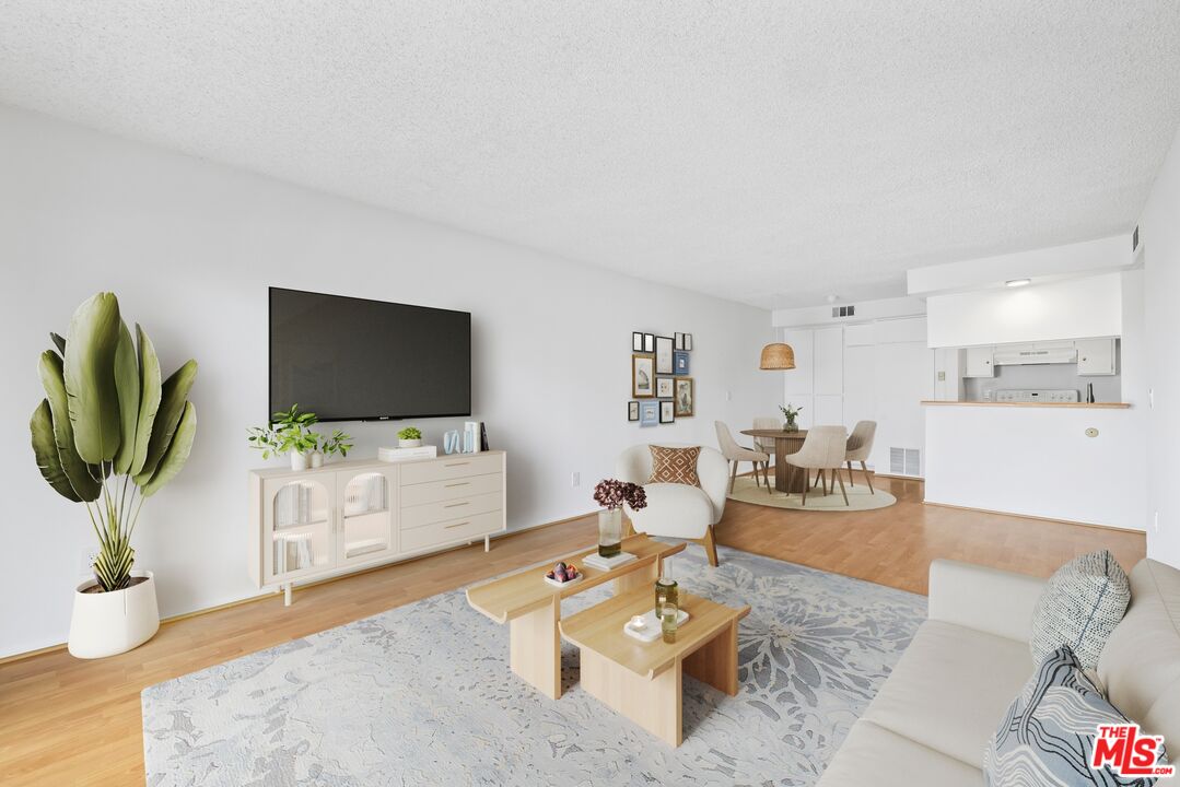 1517 East Garfield Avenue, Unit 23 Glendale, CA 91205 - Photo 1 of 14 a living room with furniture a flat screen tv and a dining table with wooden floor