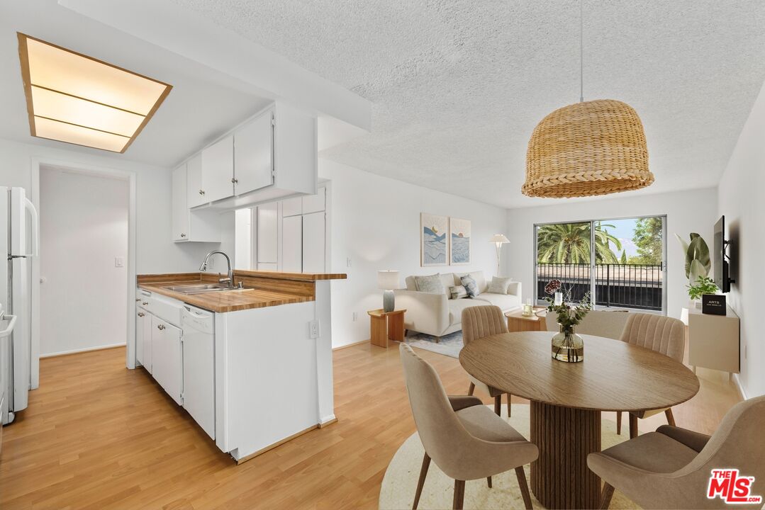 1517 East Garfield Avenue, Unit 23 Glendale, CA 91205 - Photo 4 of 14 a kitchen with stainless steel appliances granite countertop a stove a kitchen island a white cabinets a dining table and chairs