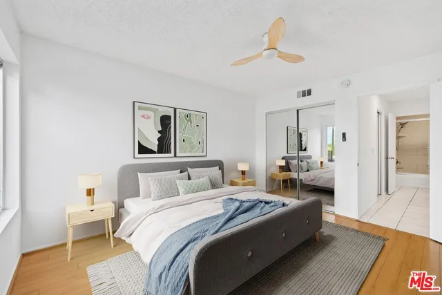 a spacious bedroom with a bed and wooden floor