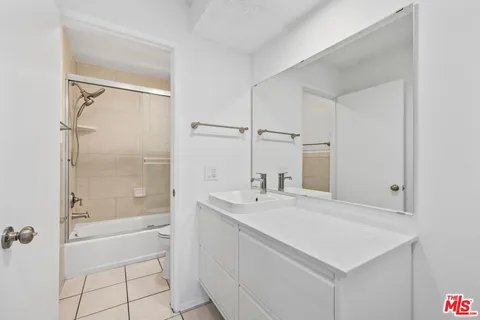 a bathroom with a sink a shower and a mirror