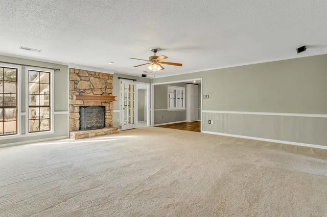 a view of an empty room with a fireplace and a window