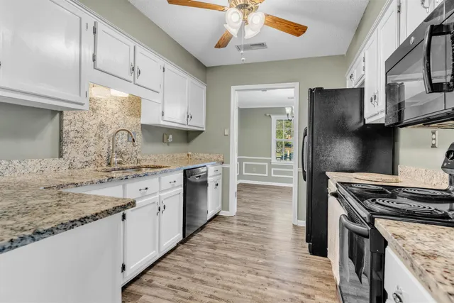 a kitchen with stainless steel appliances granite countertop a stove sink and cabinets