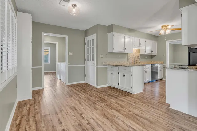 a large kitchen with cabinets and wooden floor