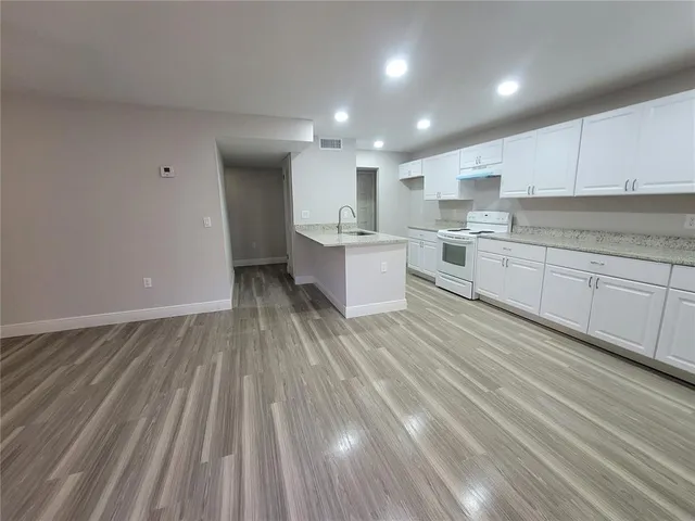 a large kitchen with kitchen island sink stove and cabinets