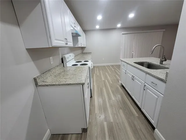 a kitchen with a sink stove and cabinets