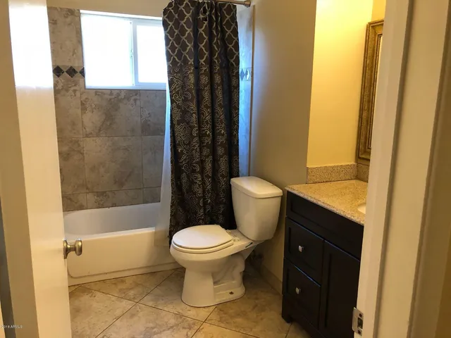 a view of a small space with wooden floor and a fan