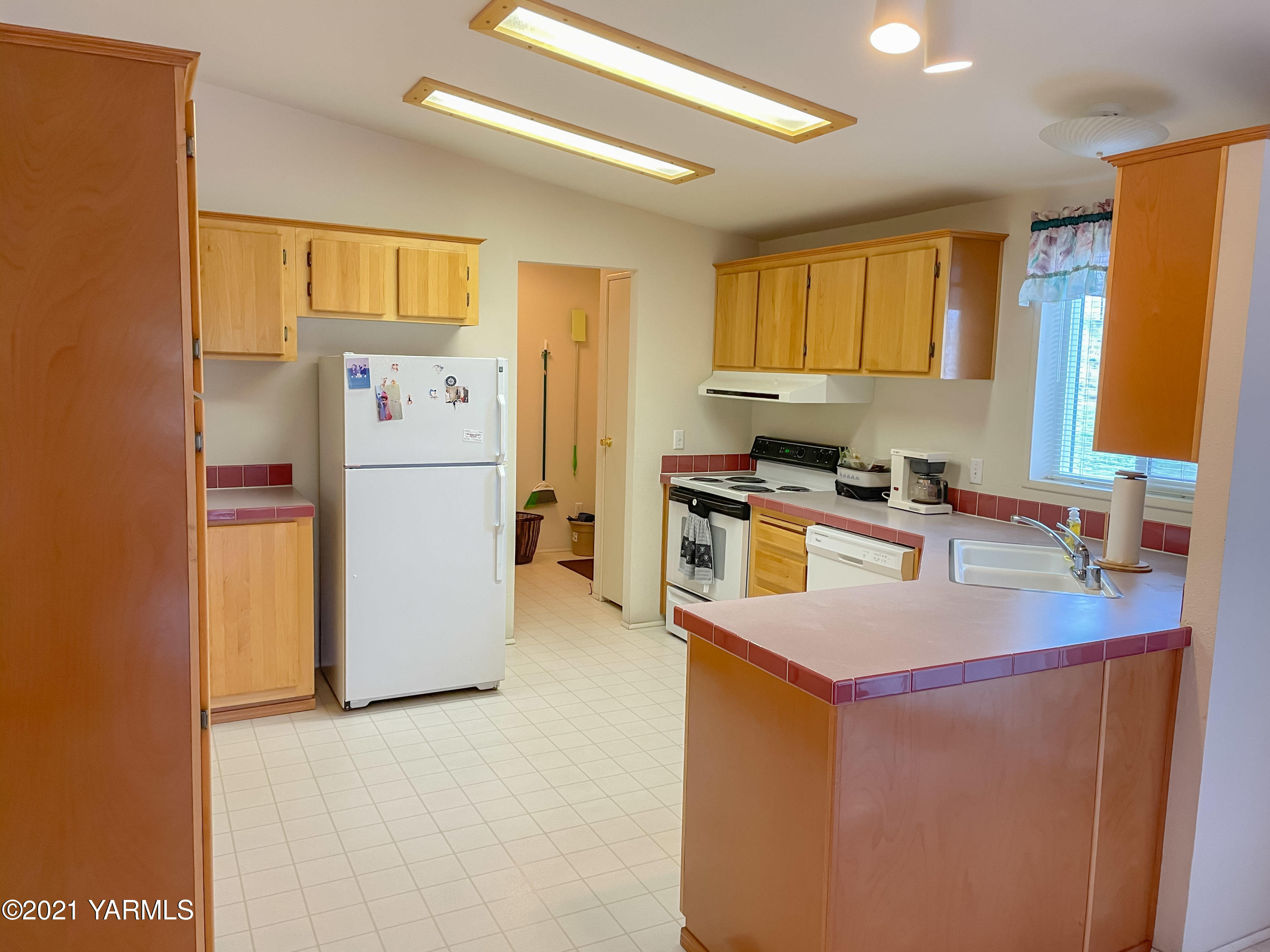 11806 Postma Road Moxee, WA 98936 - Photo 4 of 24 a kitchen with refrigerator cabinets and wooden floor