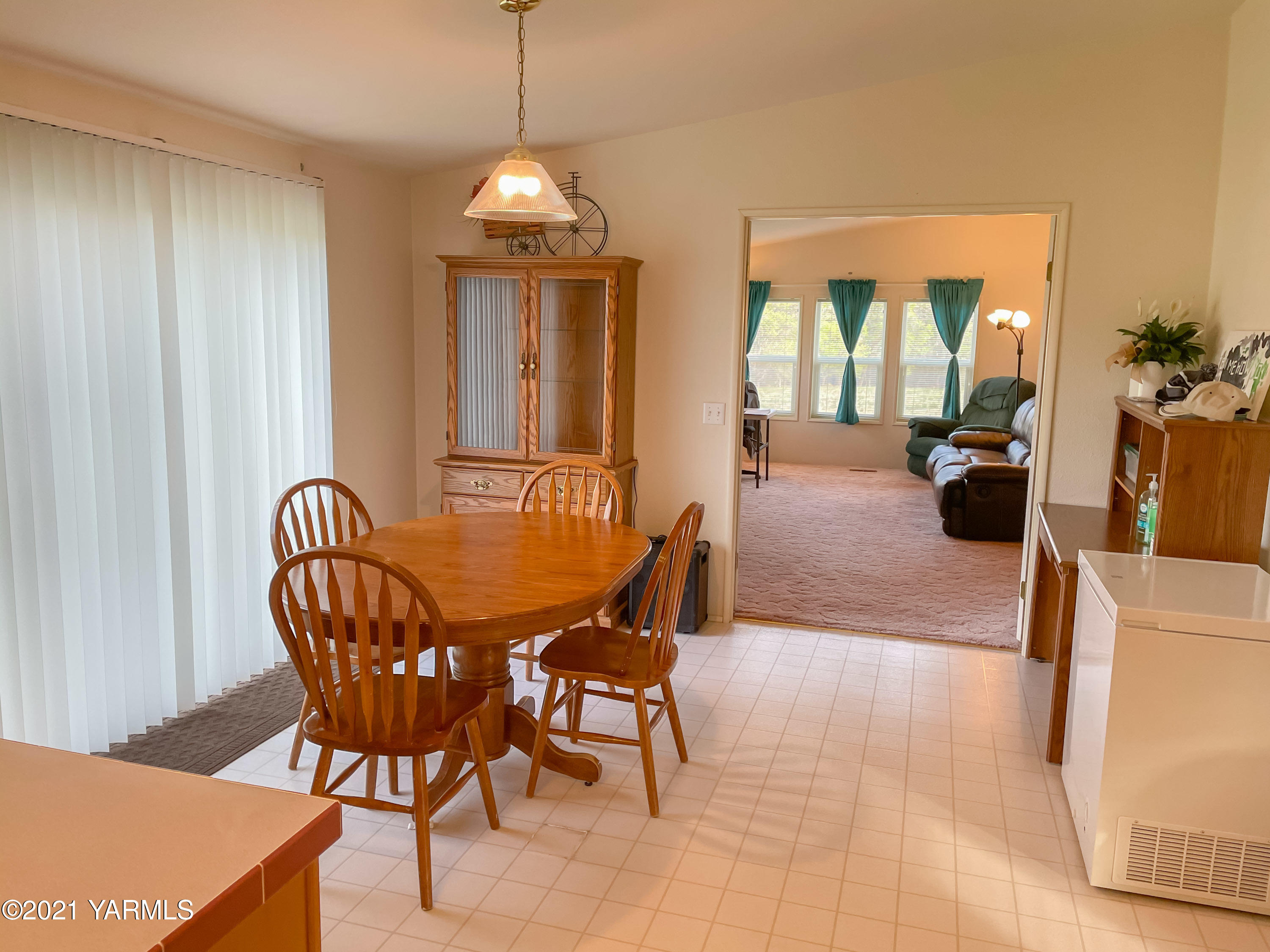 11806 Postma Road Moxee, WA 98936 - Photo 7 of 24 a dining room with furniture wooden floor a rug a potted plant and a chandelier