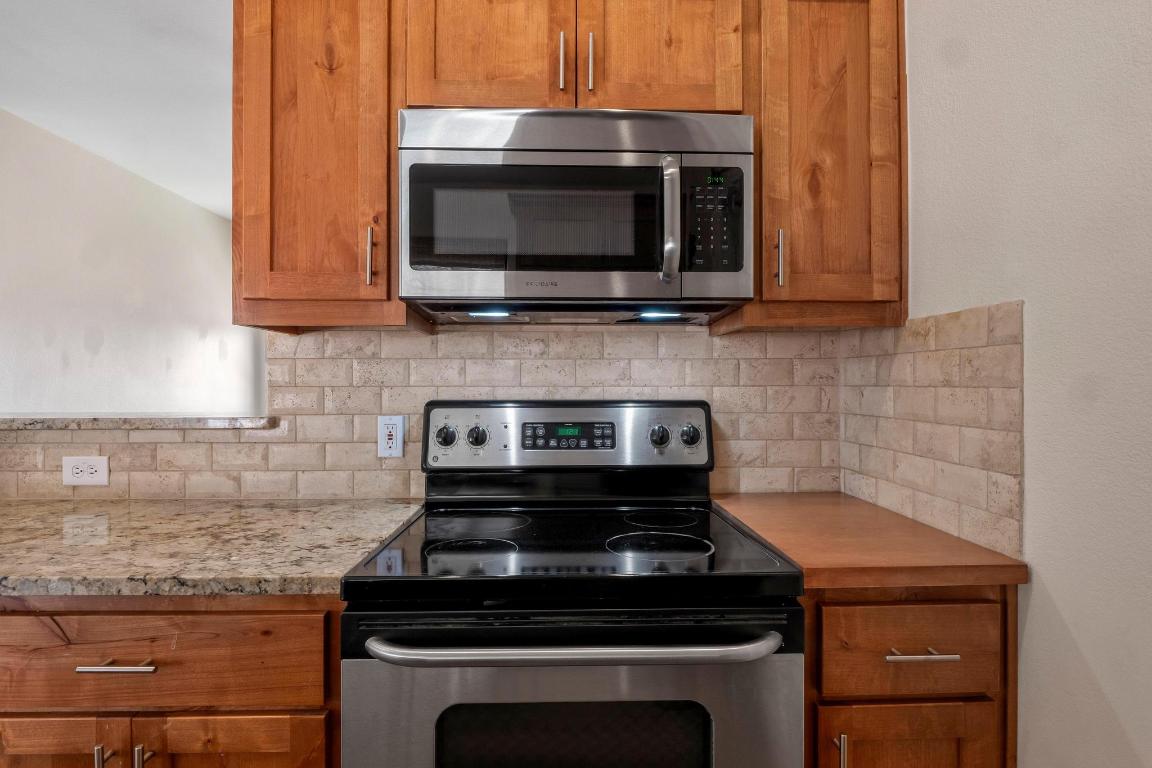 10213 Thomas Lane Dripping Springs, TX 78620 - Photo 11 of 40 a kitchen with a stove and a microwave