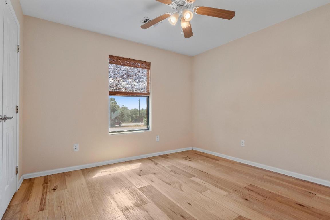 10213 Thomas Lane Dripping Springs, TX 78620 - Photo 20 of 40 wooden floor in an empty room with a window