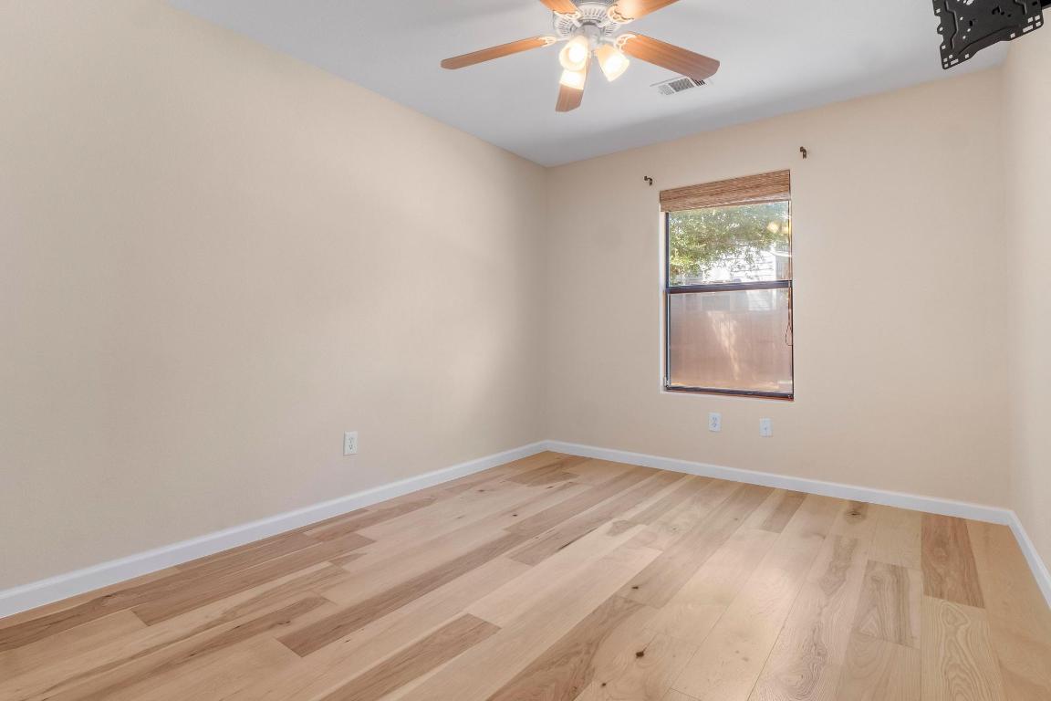 10213 Thomas Lane Dripping Springs, TX 78620 - Photo 22 of 40 an empty room with wooden floor and windows