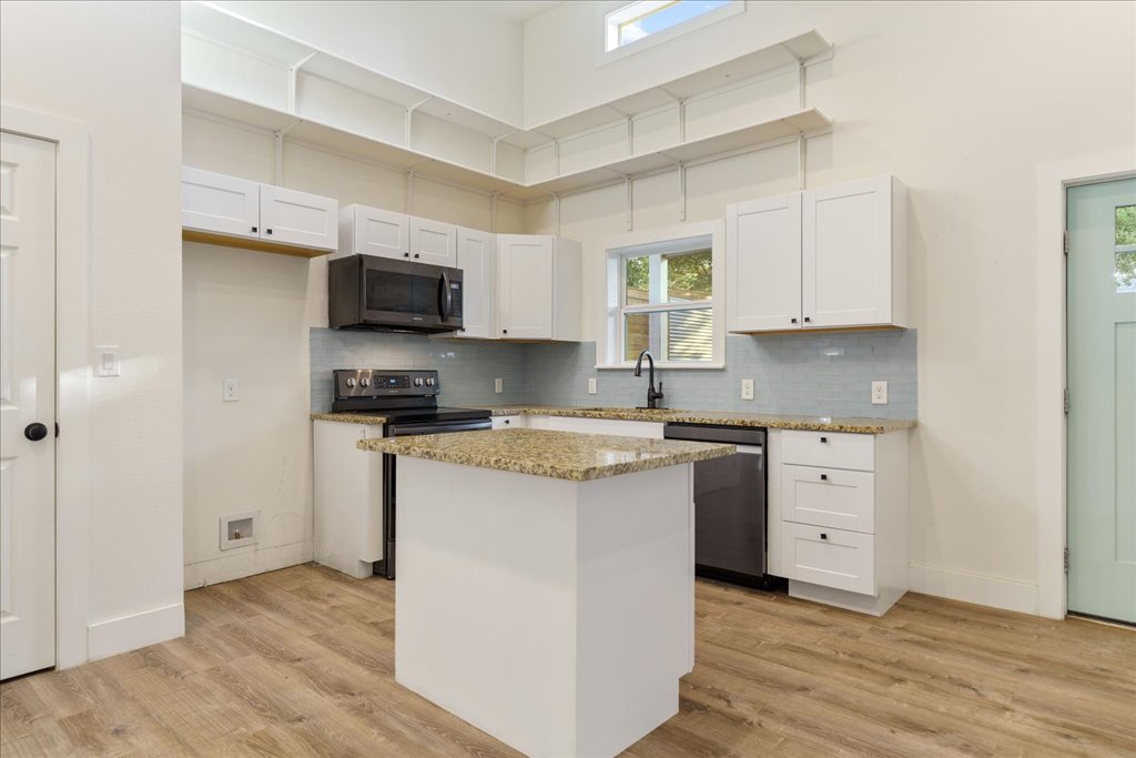 10213 Thomas Lane Dripping Springs, TX 78620 - Photo 38 of 40 a kitchen with granite countertop white cabinets and stainless steel appliances
