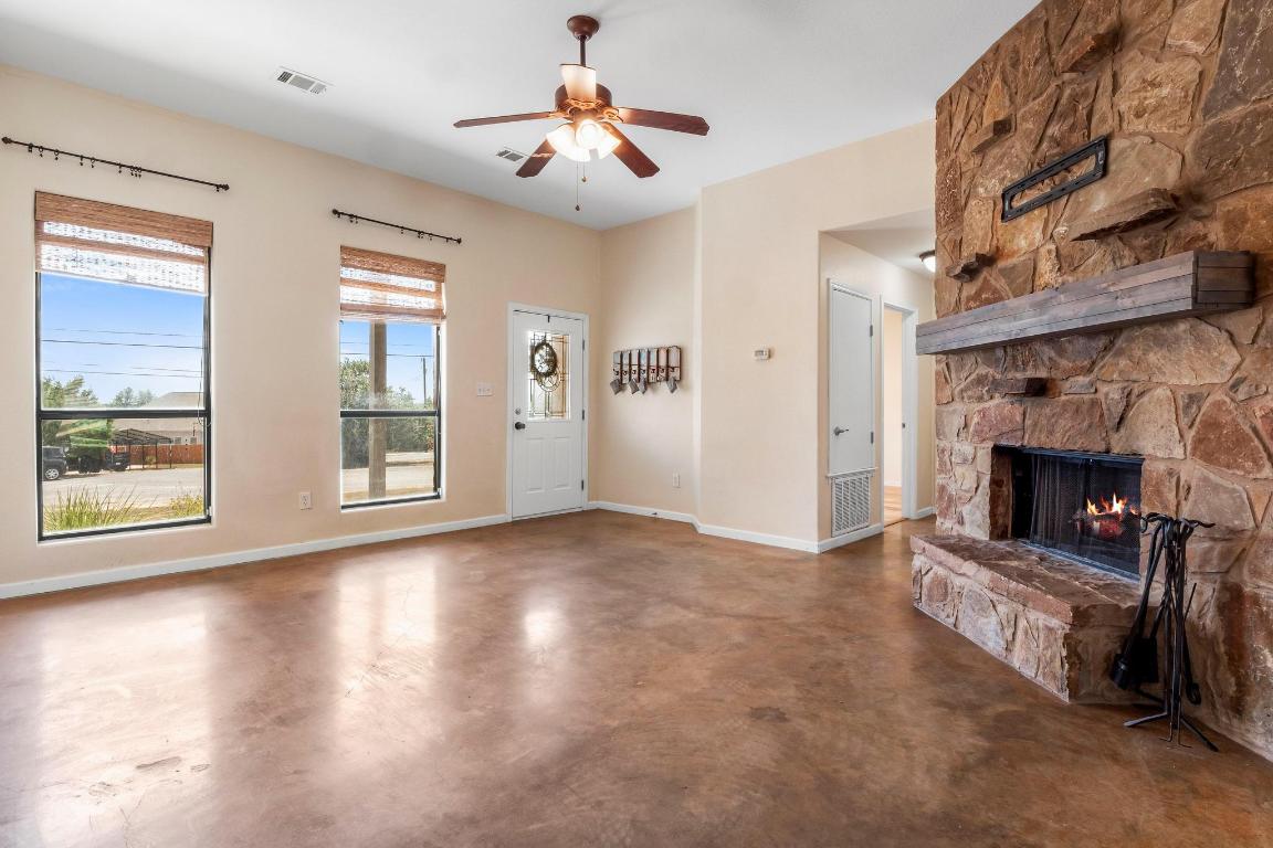 10213 Thomas Lane Dripping Springs, TX 78620 - Photo 5 of 40 a view of empty room with fireplace and wooden floor