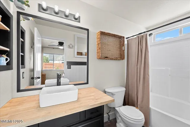 a bathroom with a sink a toilet a mirror and shower