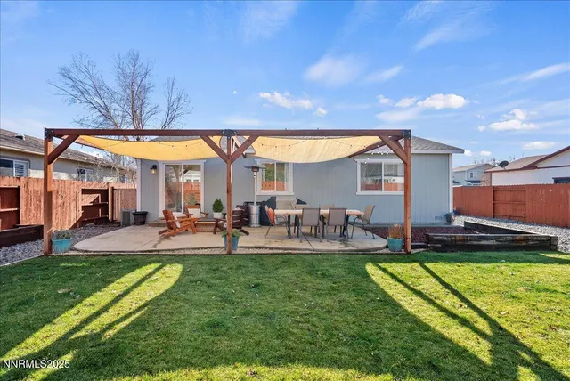a view of a house with backyard and sitting area