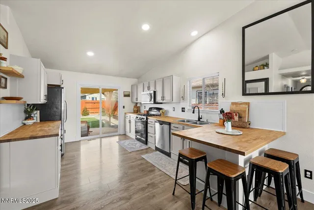 a open dining room with stainless steel appliances kitchen island granite countertop a table chairs and a refrigerator
