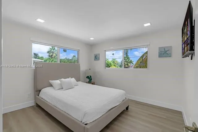a bedroom with a bed and painting on the wall