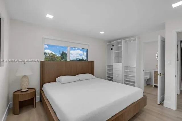 a bedroom with a bed and a large mirror