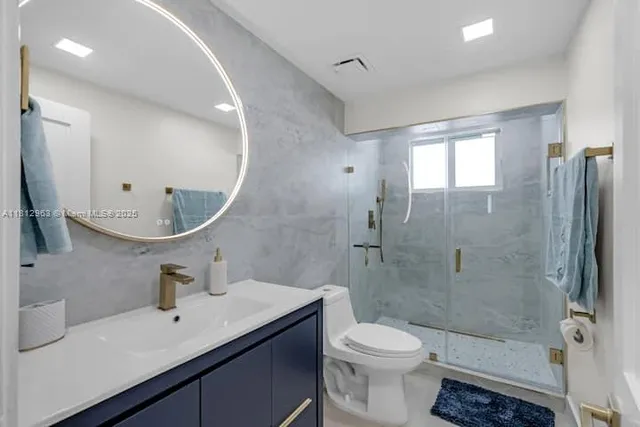 a bathroom with a sink a toilet and shower