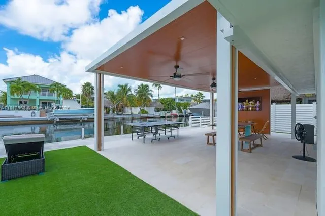 a view of a patio with table and chairs potted plants with wooden floor and fence