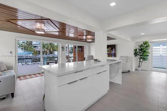 a kitchen with stainless steel appliances granite countertop a sink and a large window