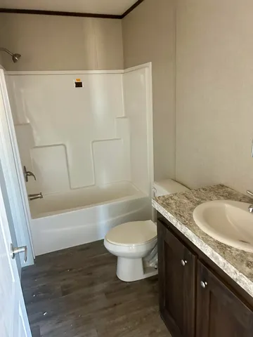 a bathroom with a granite countertop sink a toilet and a bathtub